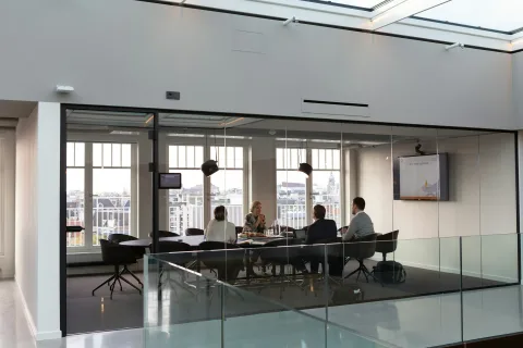 Échange collectif dans une salle de réunion ouverte sur la ville.